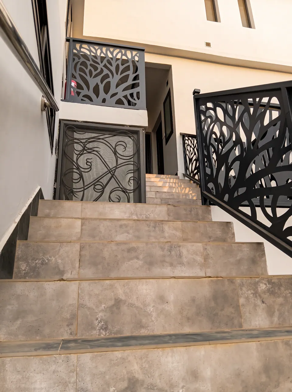 Escalier extérieur aux garde-corps en métal découpé à motif végétal